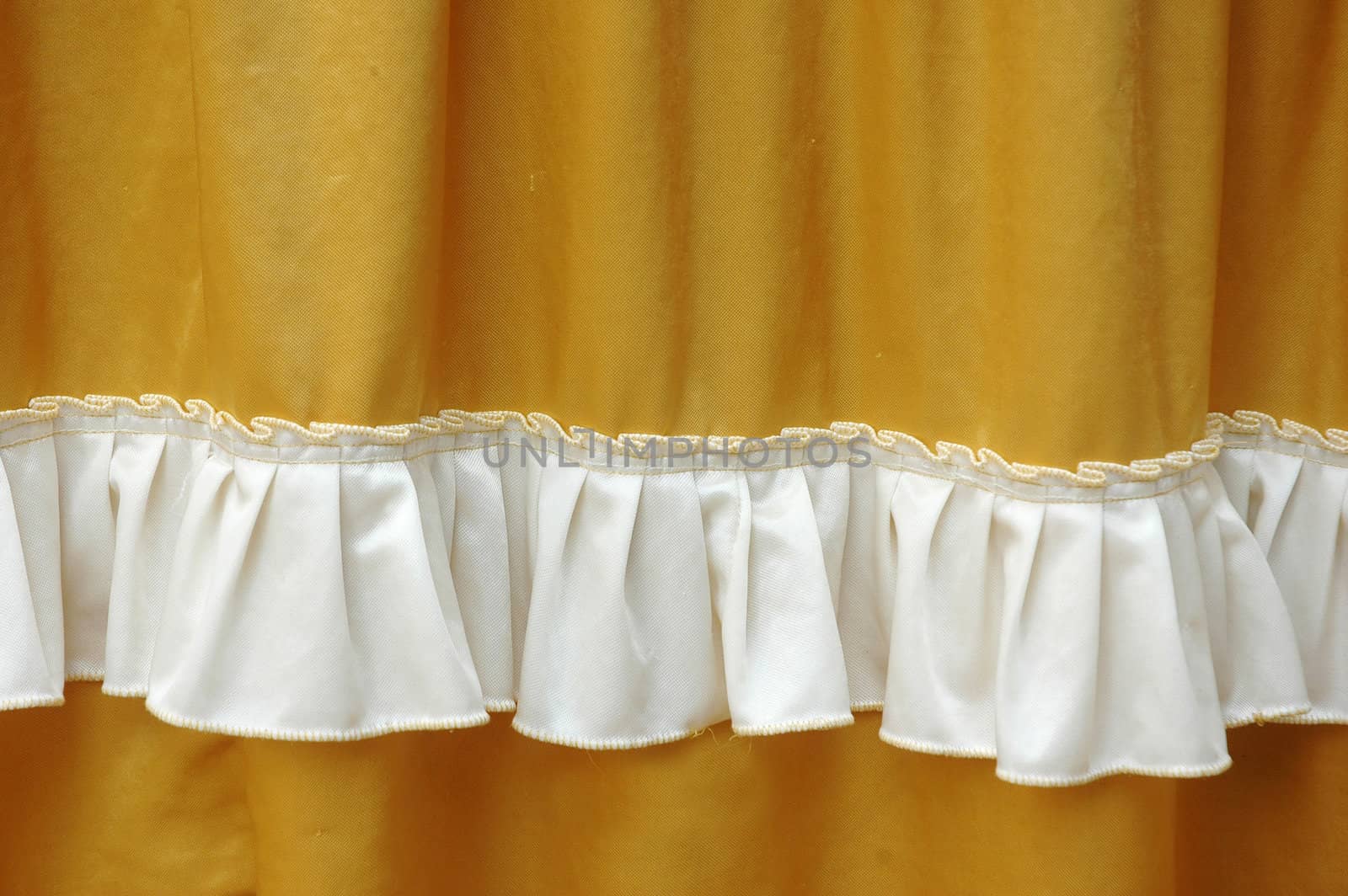 golden fabric decoration with white fringe