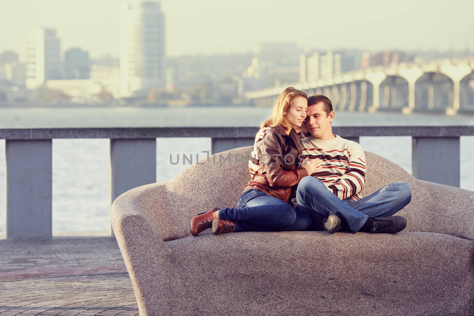 couple embracing, sitting on a background of the city