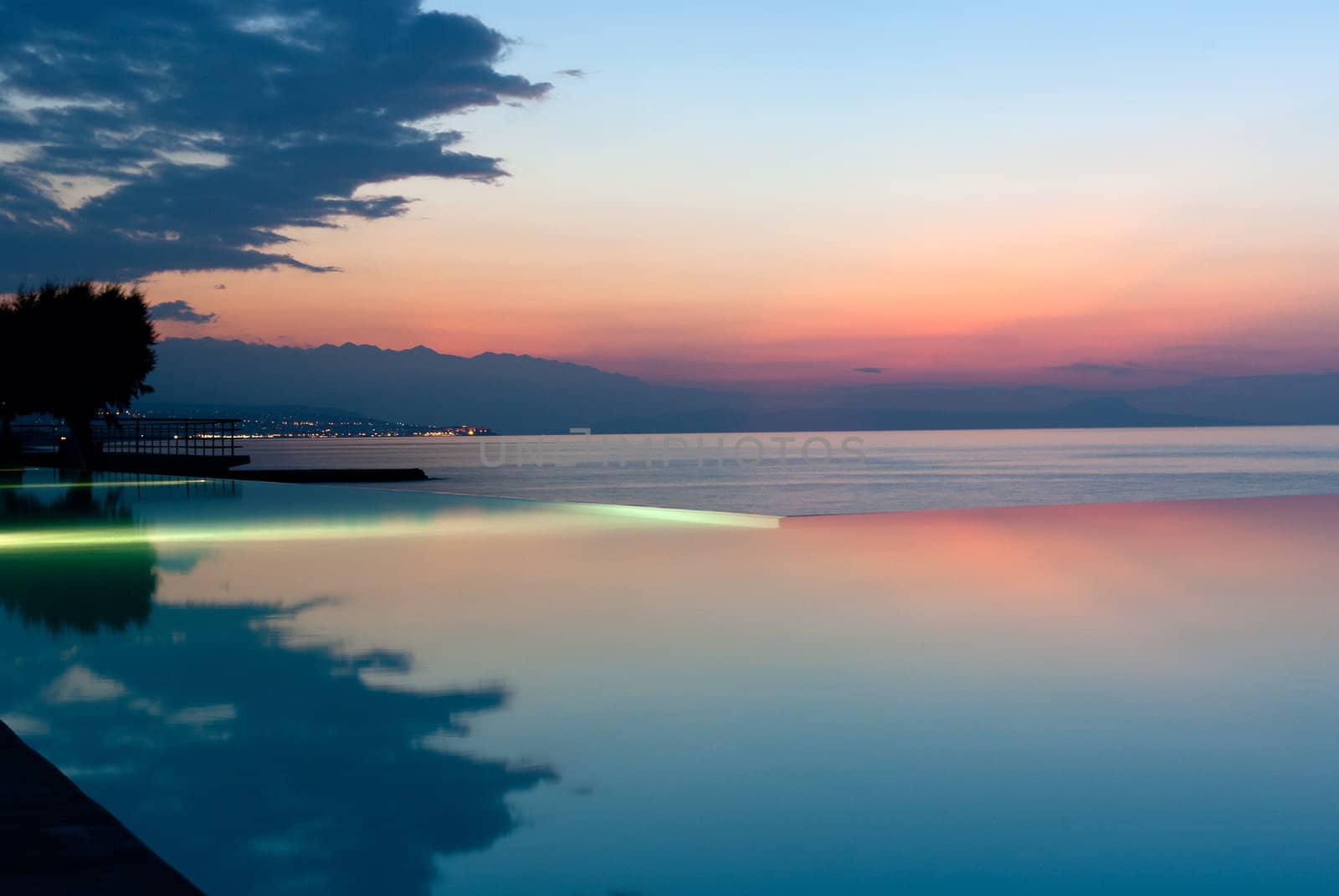 Infinity pool on the beach in luxury hotel at sunset. Crete. Greece