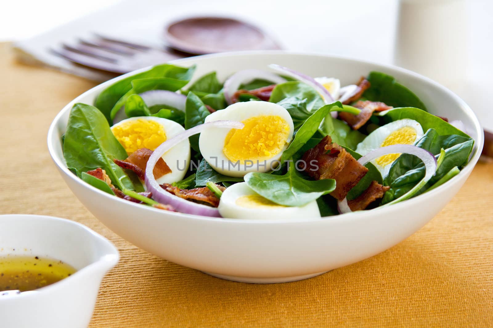 Bacon with boiled egg and spinach salad by salad dressing
