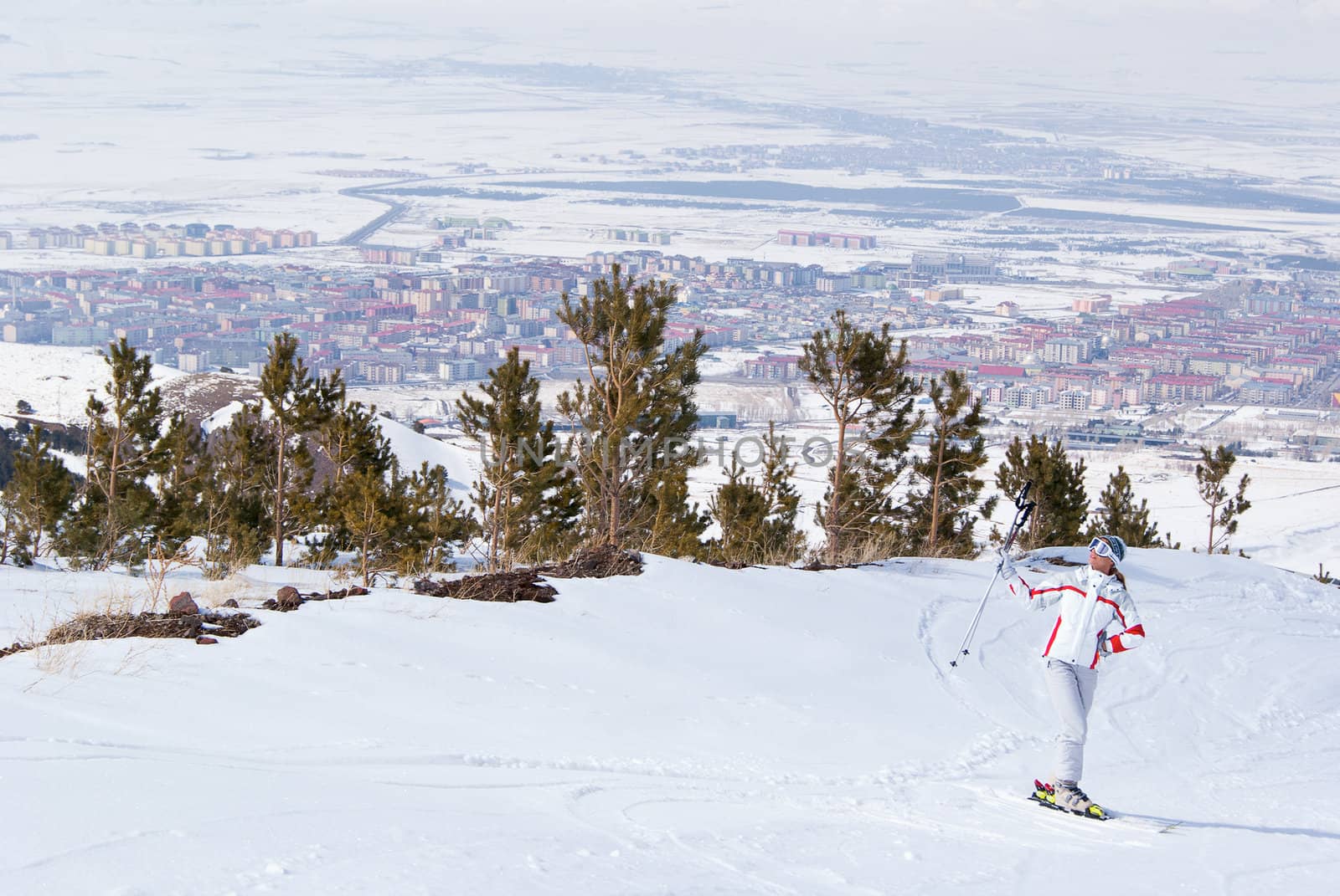 Beautiful skier posing on top of mountain in Palandoken. On the background view of Erzurum, Turkey.