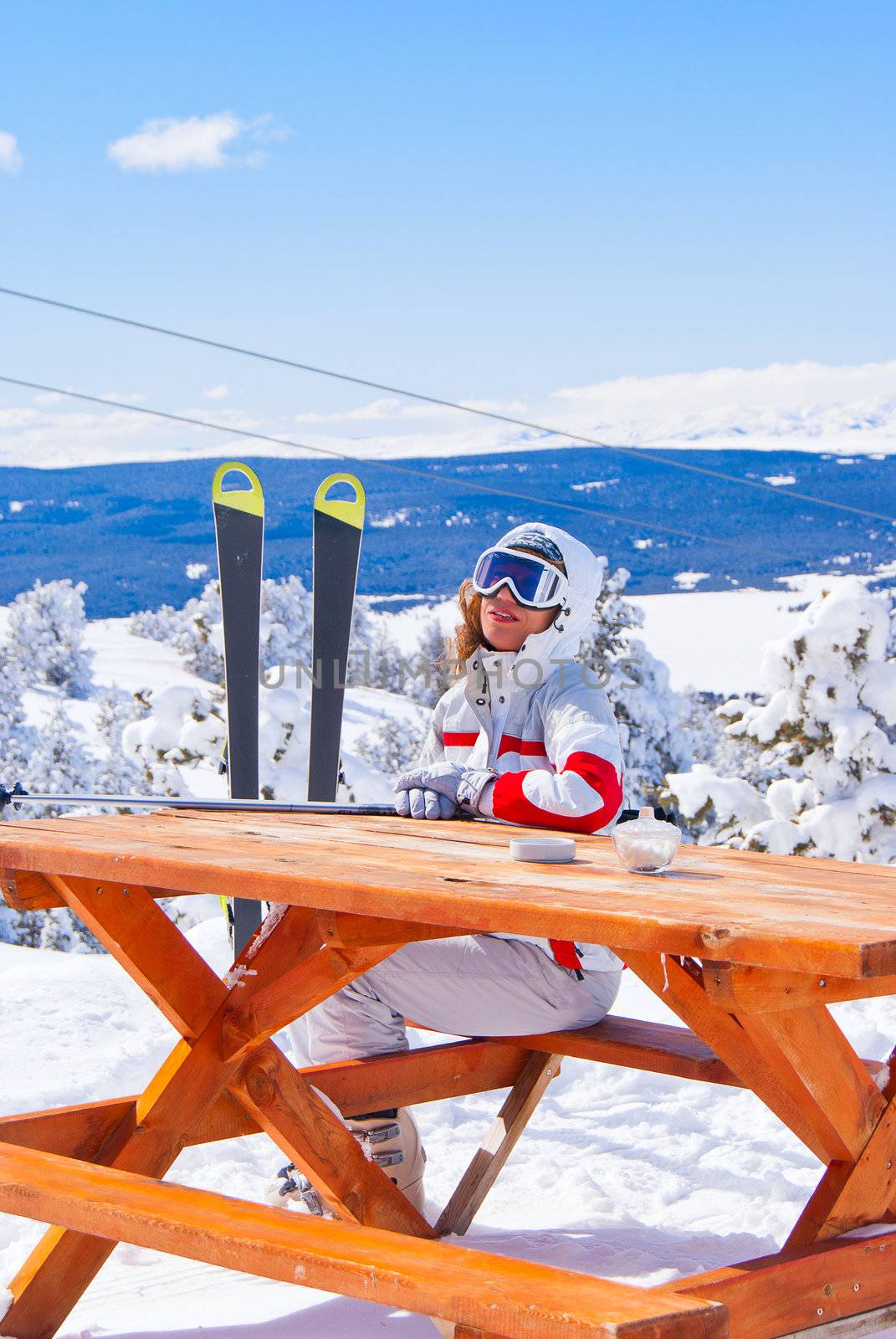 Apres ski in Sarikamis. Beautiful skier waiting for order in cafe on top of mountain.