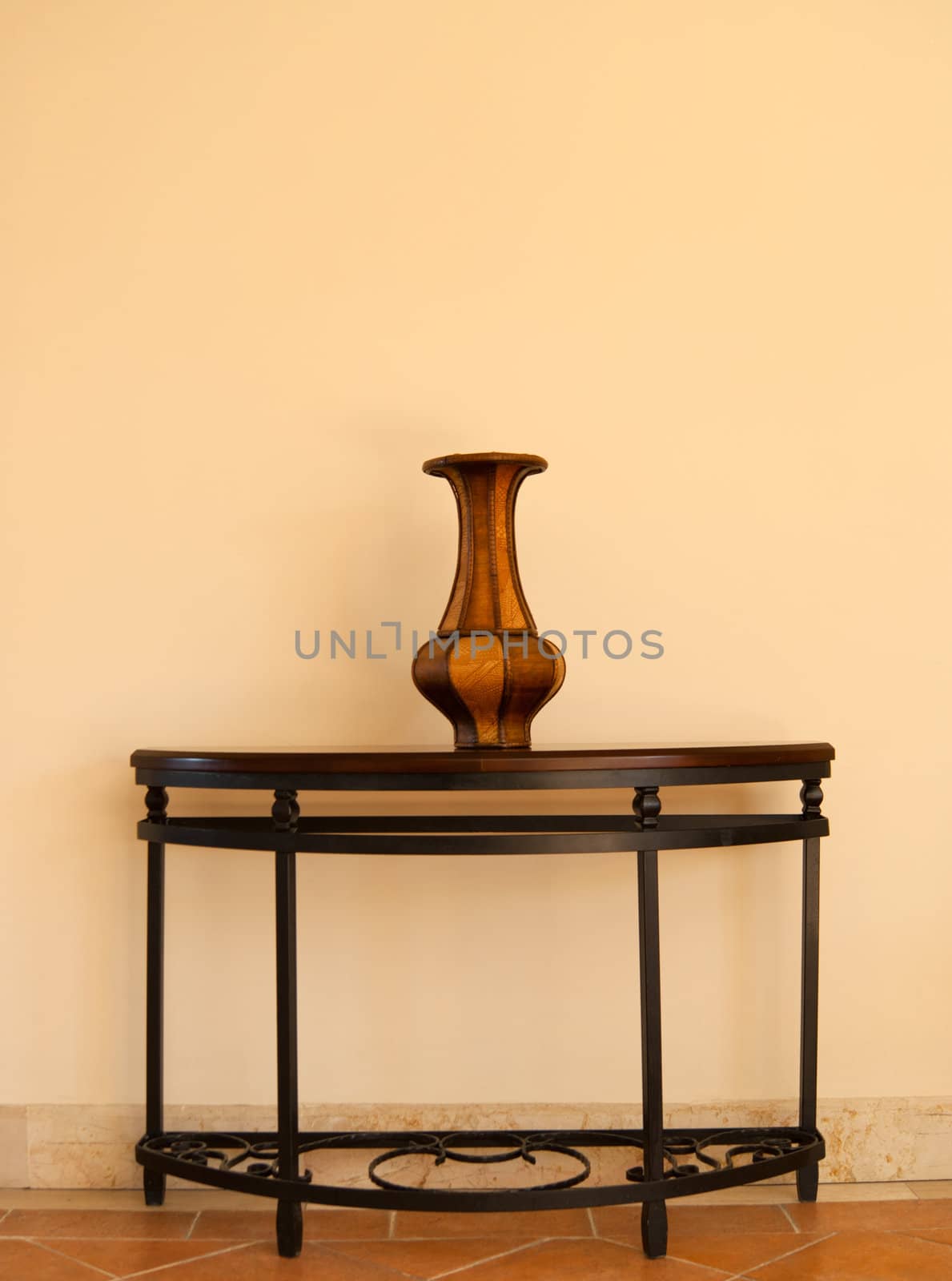 Beautiful wooden vase on table near the wall
