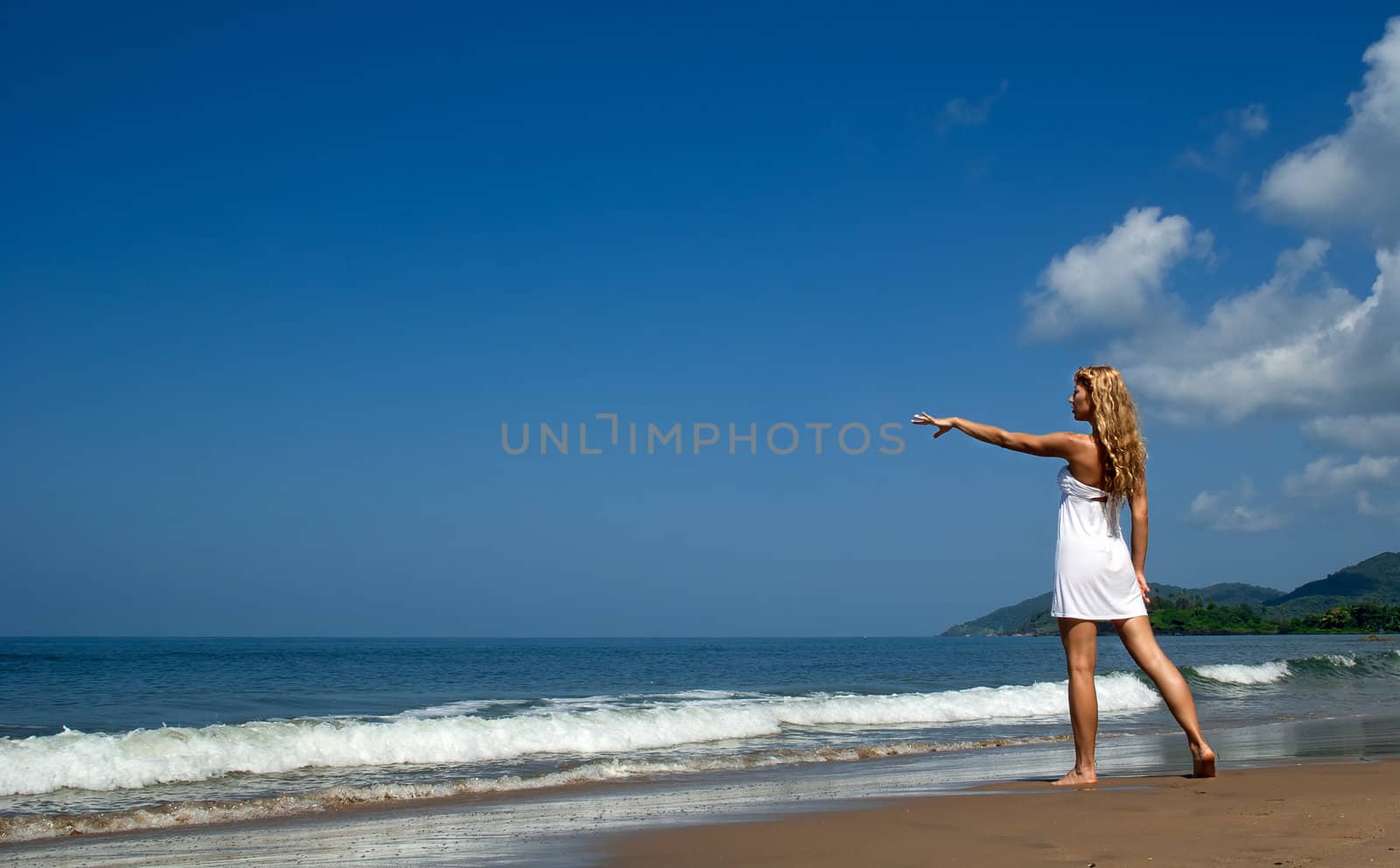 Beautiful woman on the beach looking far and point something