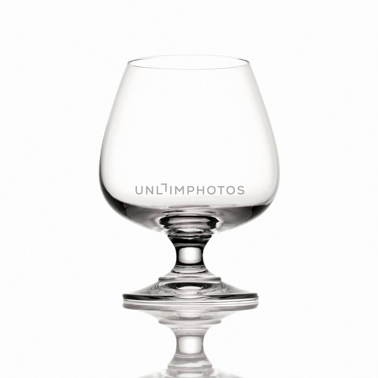 Empty Brandy glass on white background and reflection