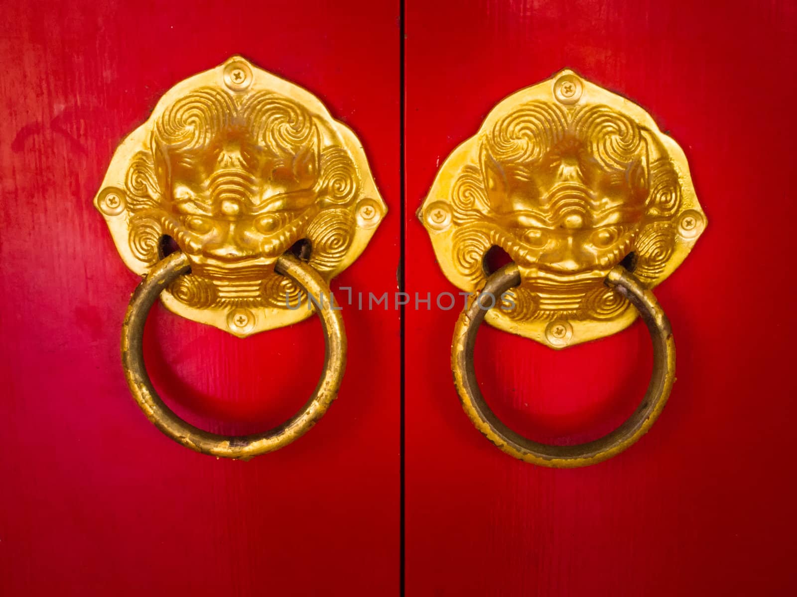 Door handle developing Chinese traditional golden head lion on red wood door