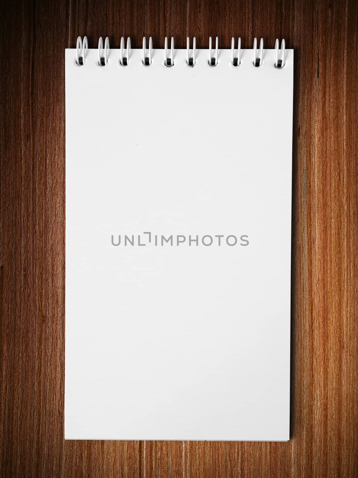 Long blank white note book vertical on wood table background