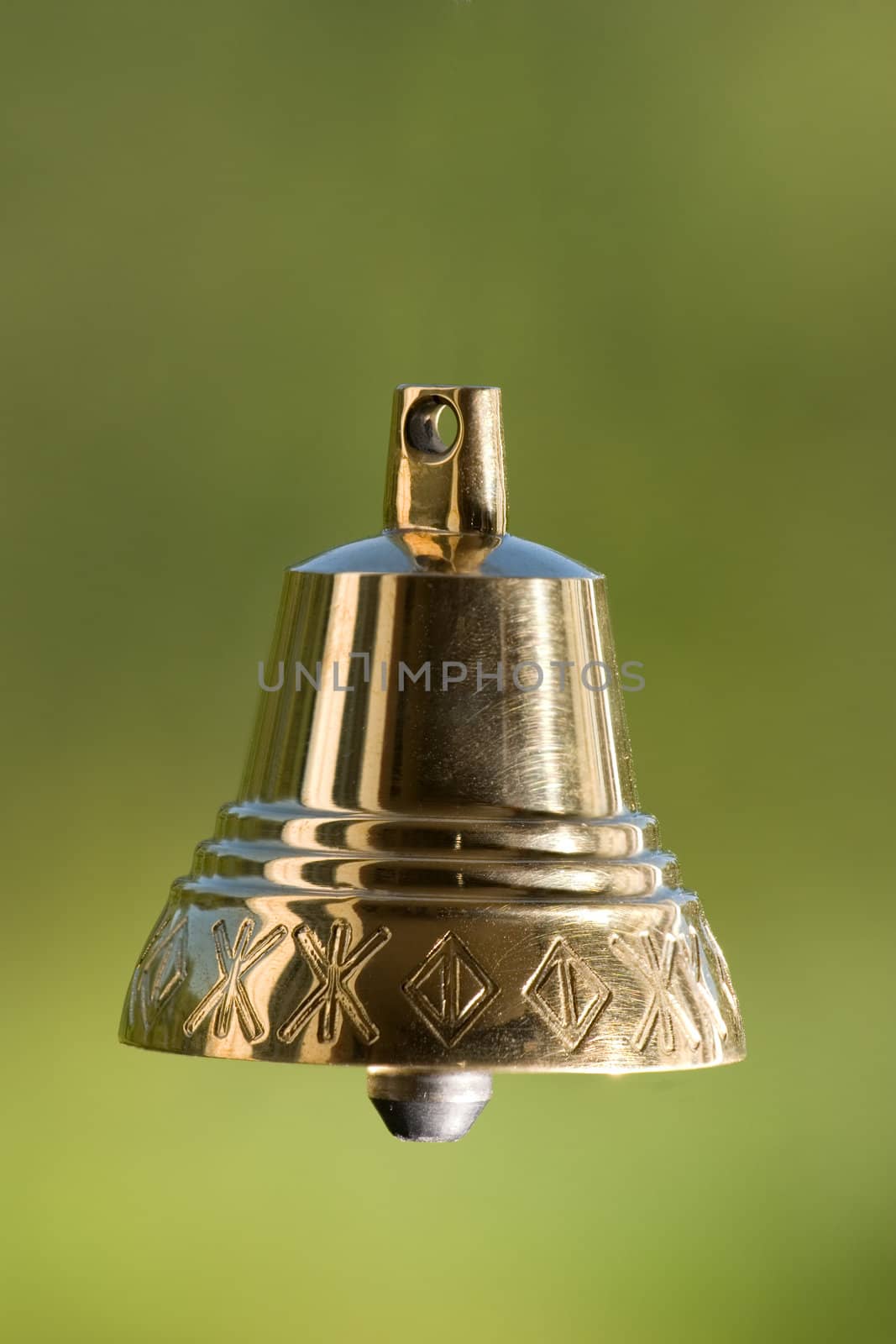 Four brass handbell on a green background