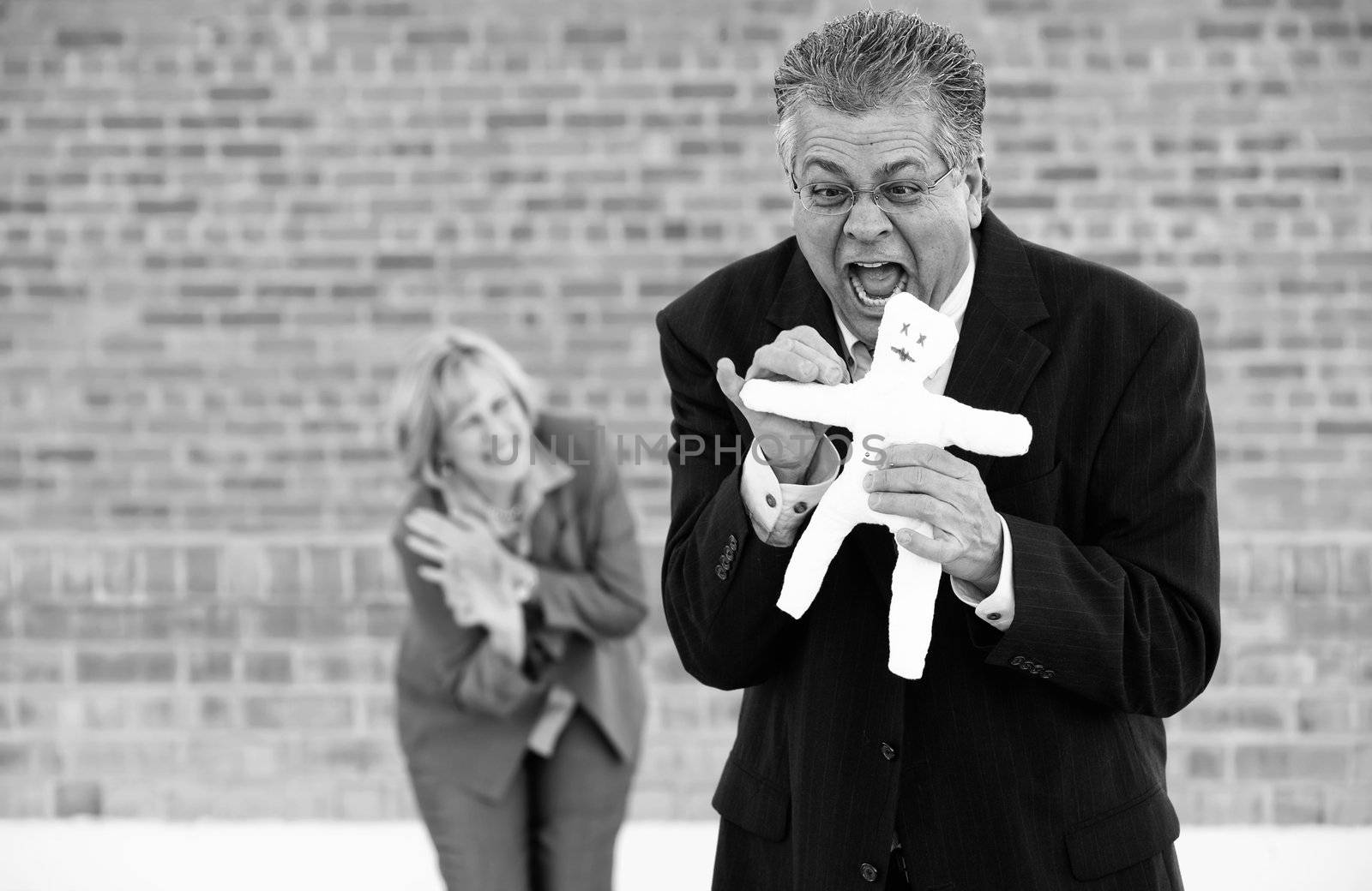 Executive pokes a pin into a Voddoo doll representing her boss or coworker