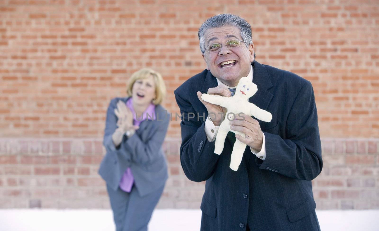 Executive pokes a pin into a Voddoo doll representing her boss or coworker