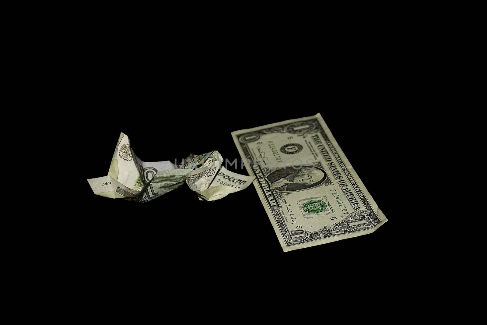 Crushed banknote in 10 roubles and a banknote in 1 dollar on a black background