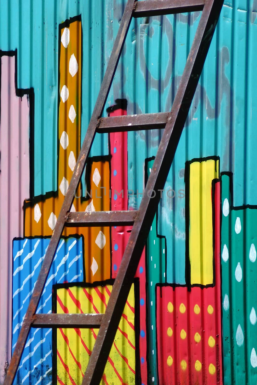 Rusted ladder and the abstract city drawn on a wall