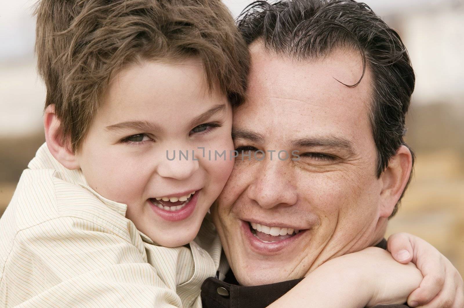 Portrait of a young boy hugging a man and laughing