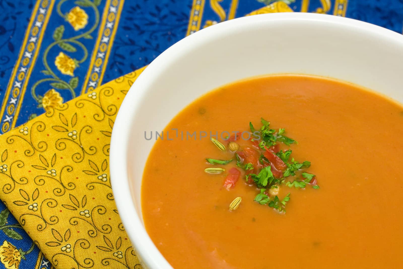 Fresh red pepper and roasted tomato soup on a mediterranean tablecloth