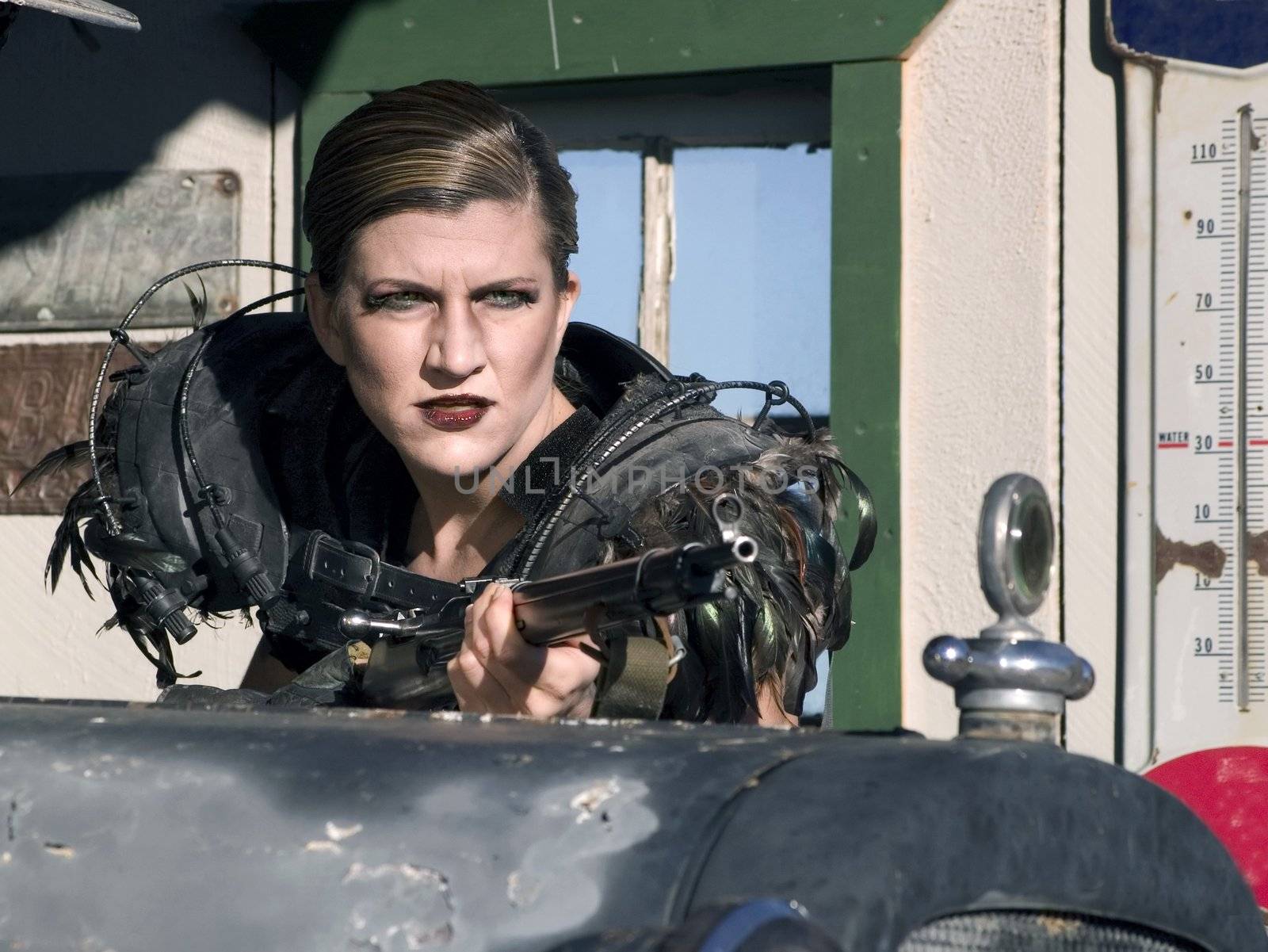 Science fiction woman hides with a rifle behind a vintage car.