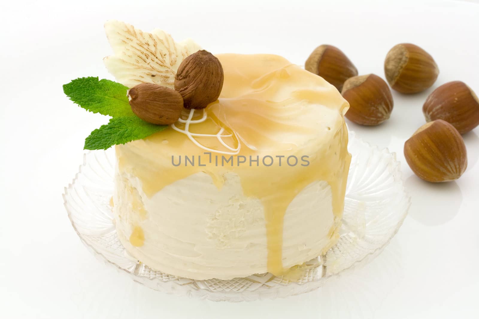 Hazelnut and maple syrup cake decorated with fruits on a transparent plate