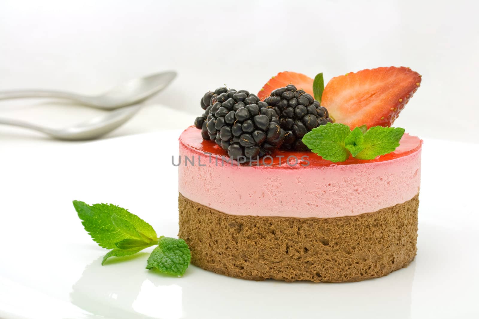 Chocolate and strawberry cake decorated with mulberries and mint leaves