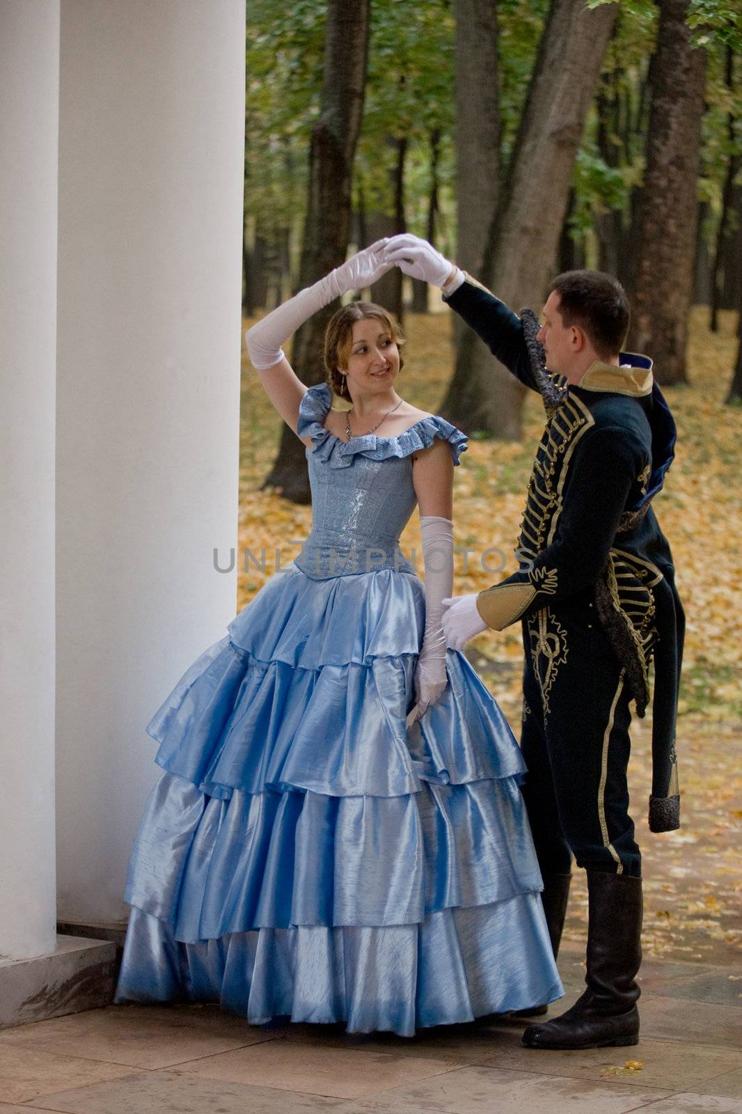 Lady and hussar in  XIX century dress in the park 
