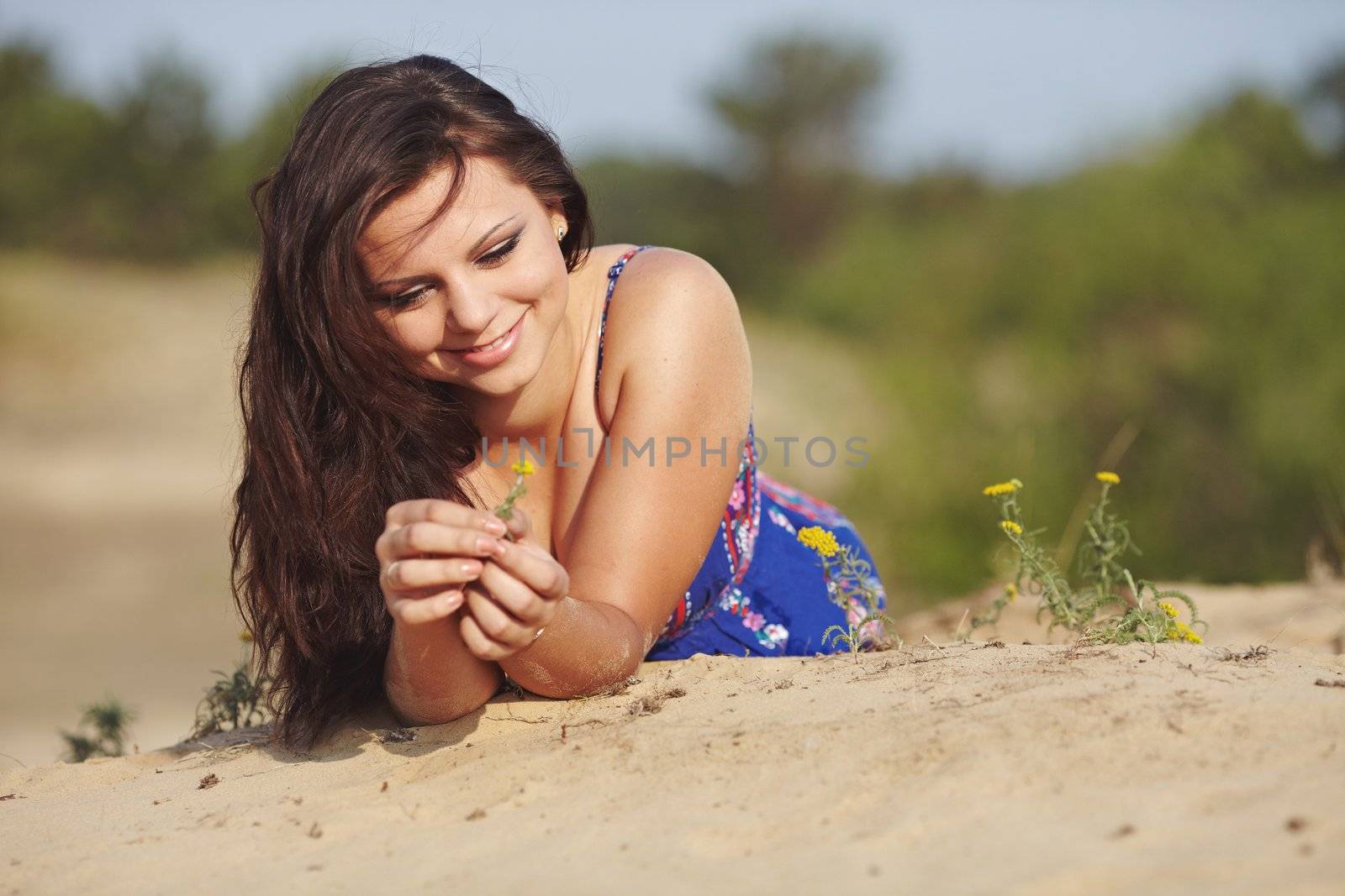 Girl going for a walk in-field and on sand. Beauty and calmness.