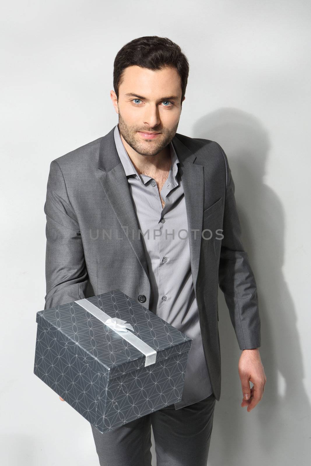 Office clerk with gift box on gray background