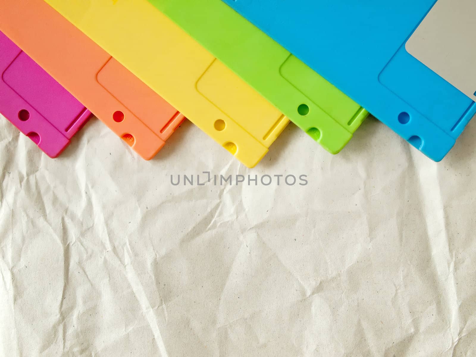 five color of old floppy disk on white crumpled paper