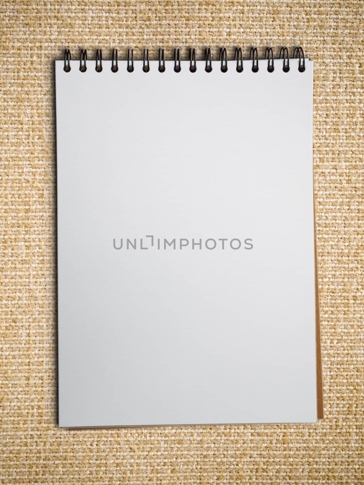 white blank note book on Light brown fabric background