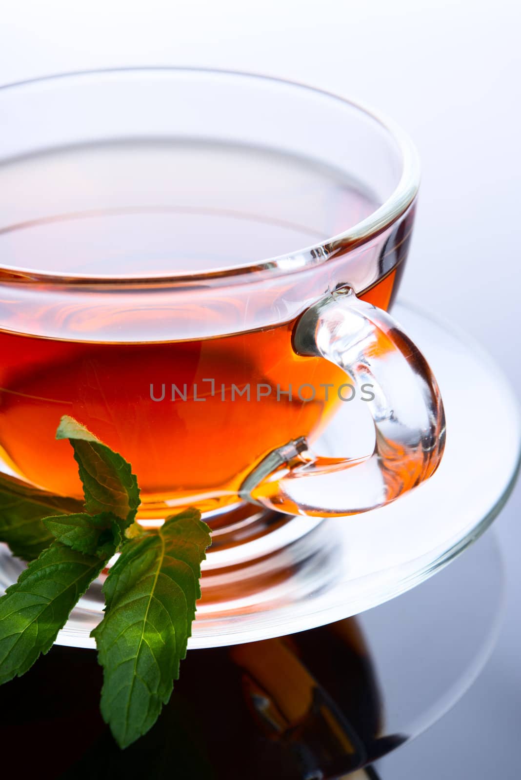 Cup of tea with mint leaf on a saucer