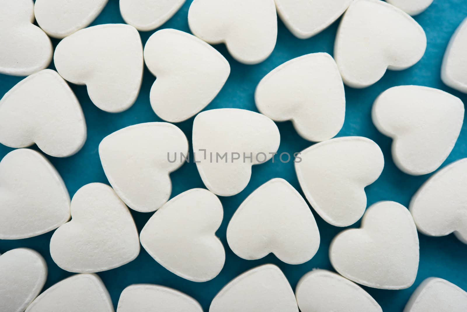 Pills as a heart on blue background