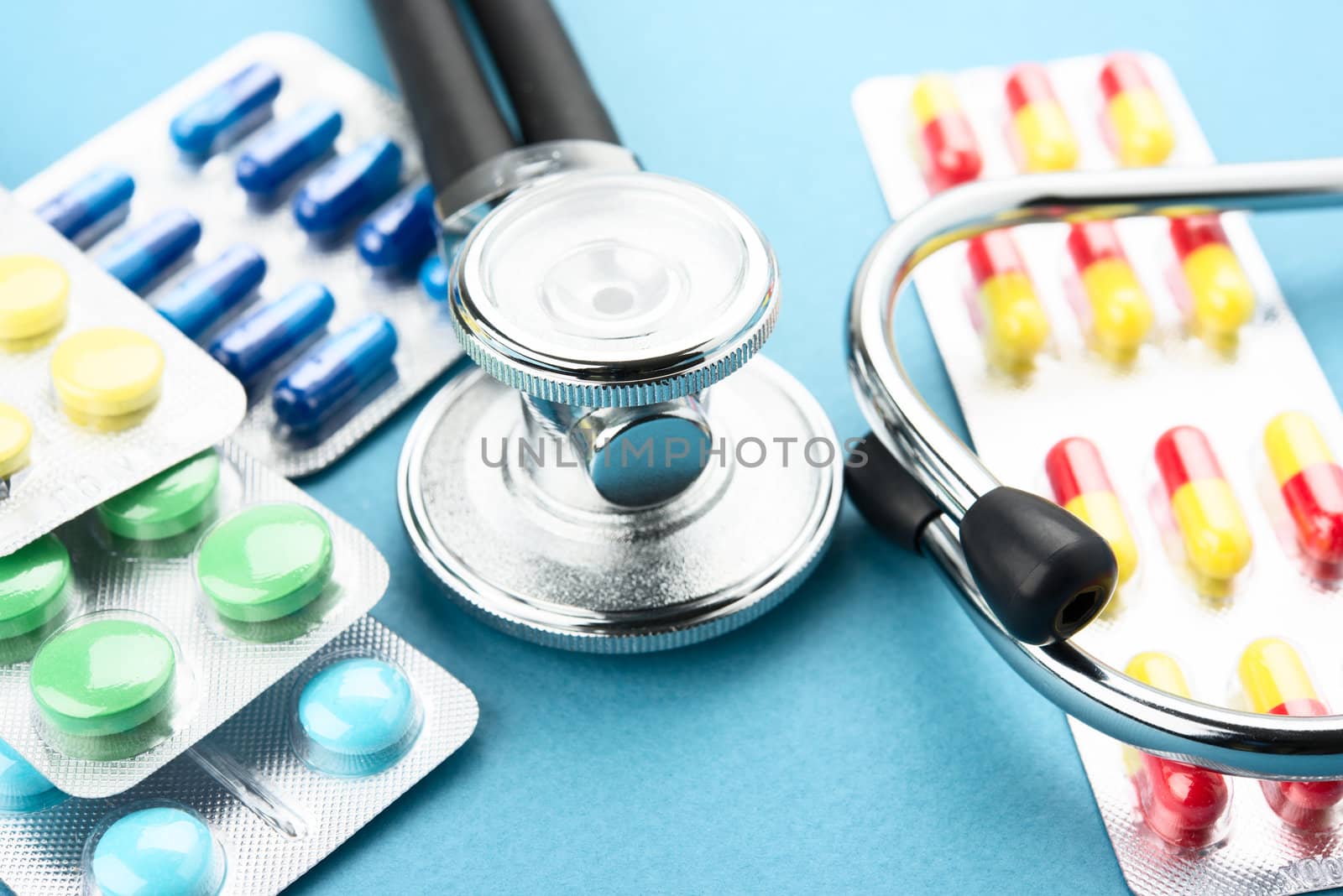 Pills and stethoscope on blue bacground