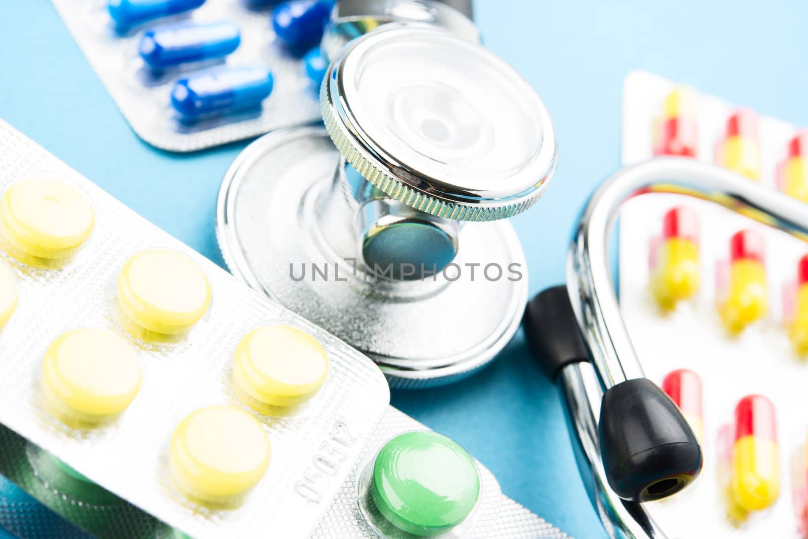 Pills and stethoscope on blue bacground