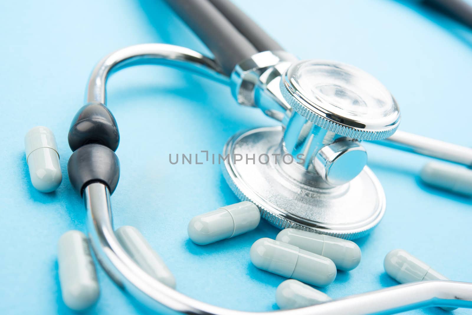 Pills and stethoscope on blue bacground