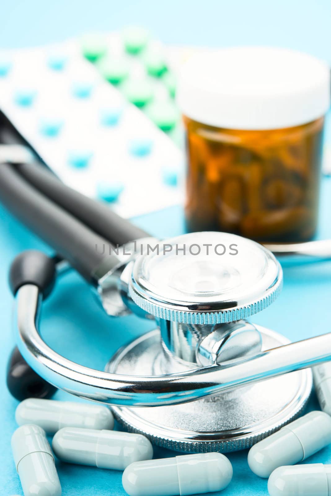 Pills and stethoscope on blue bacground