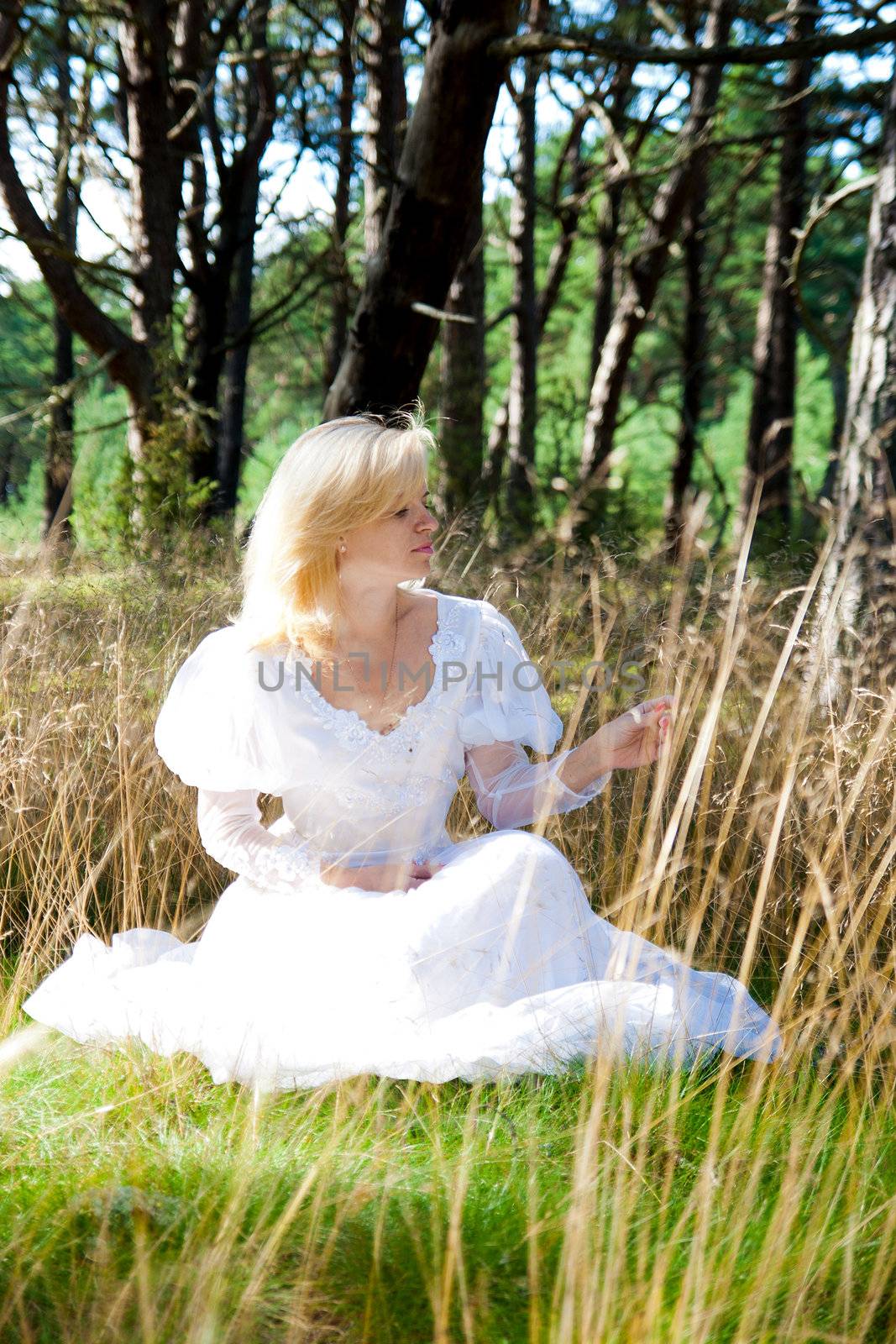 Woman sitting in forest meadow