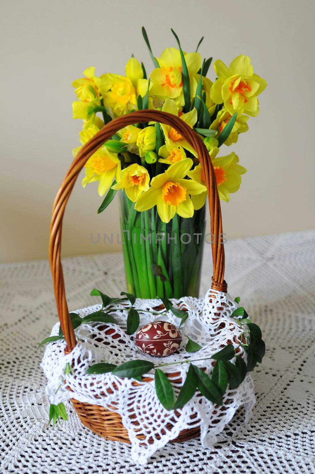 Basket with Easter eggs and daffodils on a table