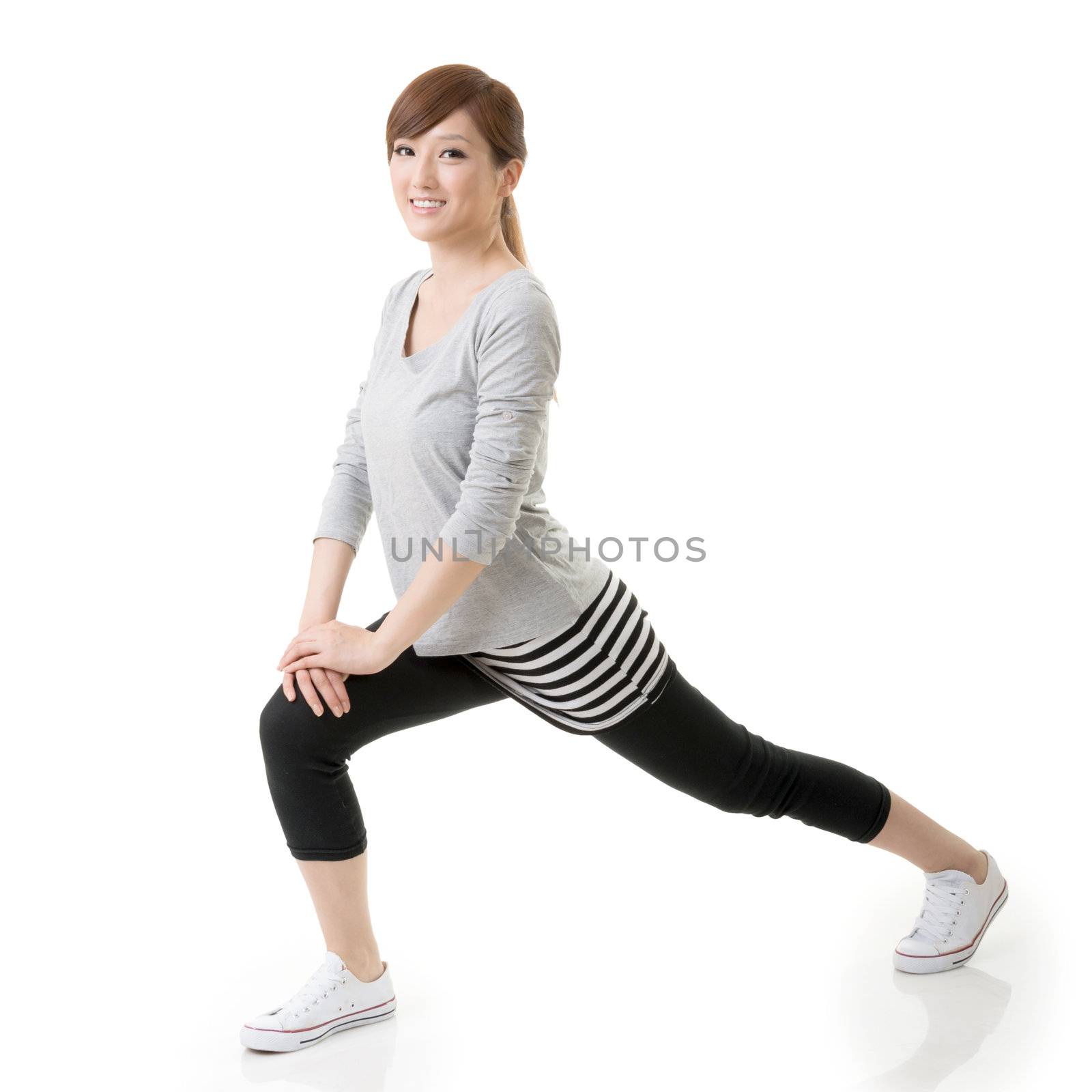 Fitness Asian girl doing stretch exercise, full length portrait isolated on white background.