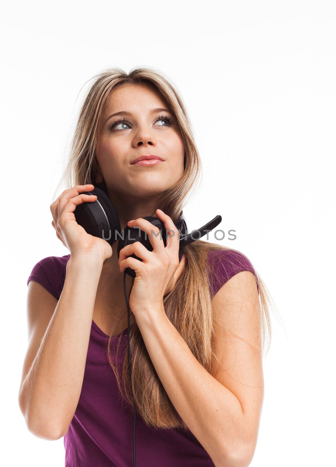 Beautiful young woman with headphones looking up, on white