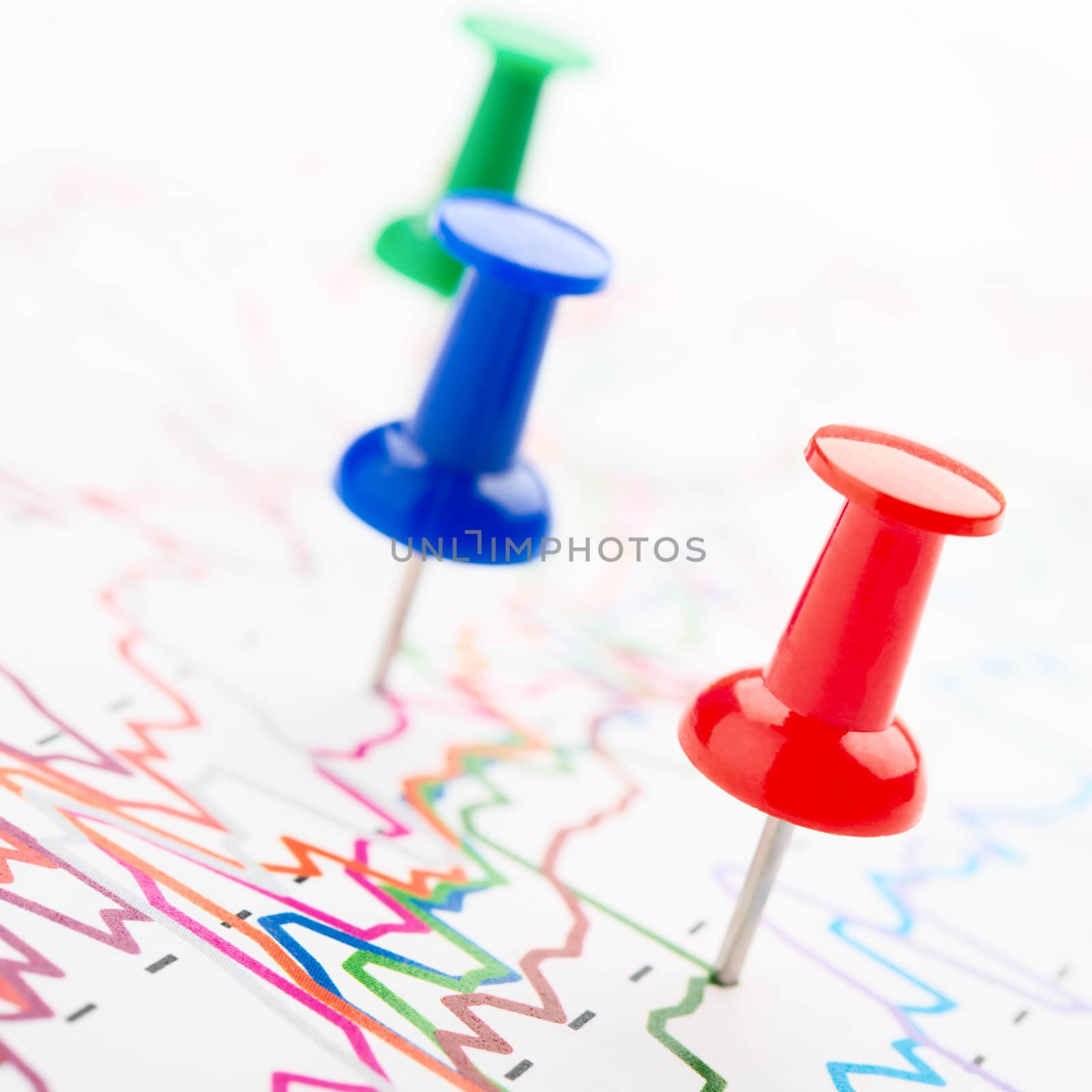 Close-up of red, blue and green pins on graphic
