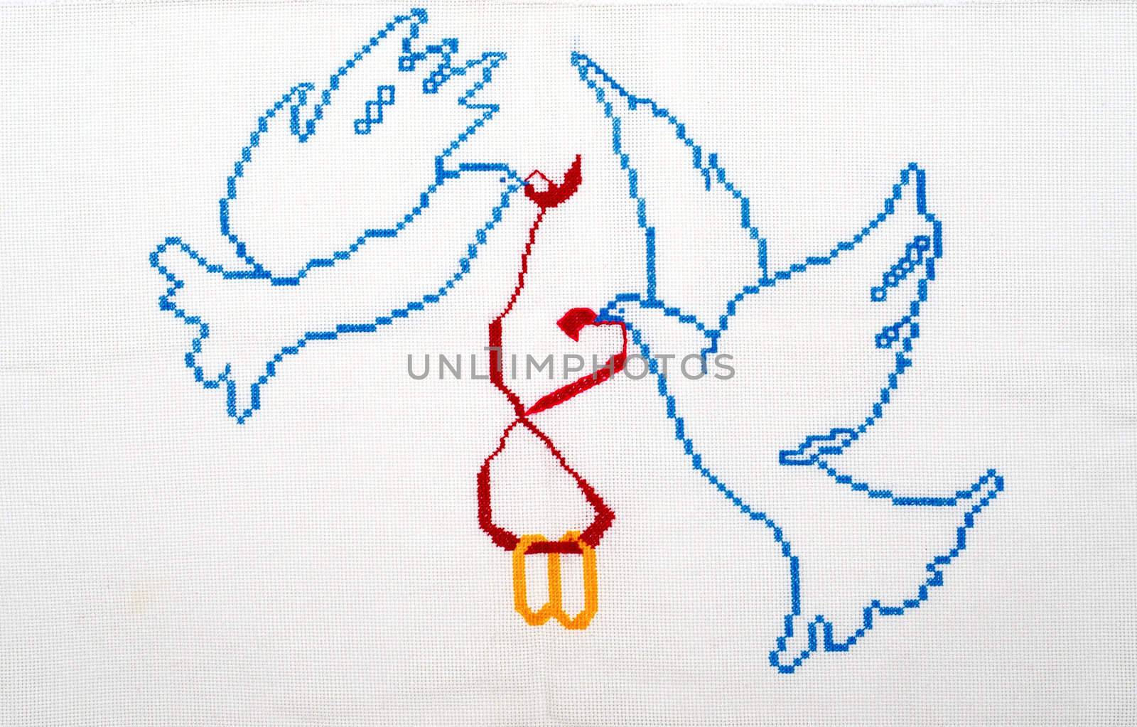 Embroidered good by cross-stitch pattern. White doves holding wedding rings