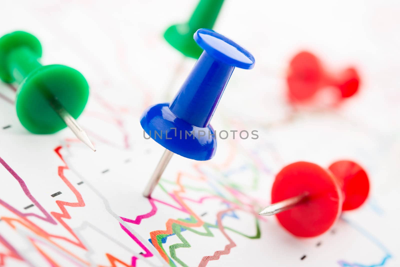 Close-up of red, blue and green pins on graphic