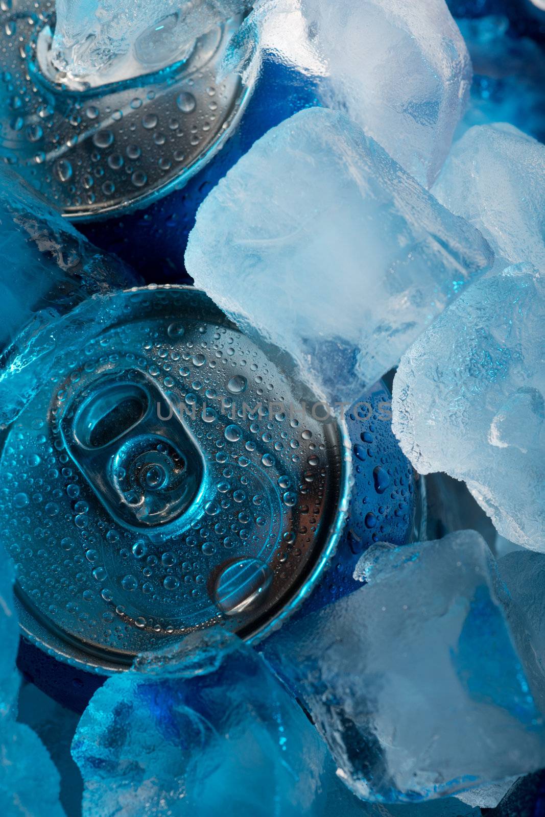 Wet aluminium cans under ice cubes closeup