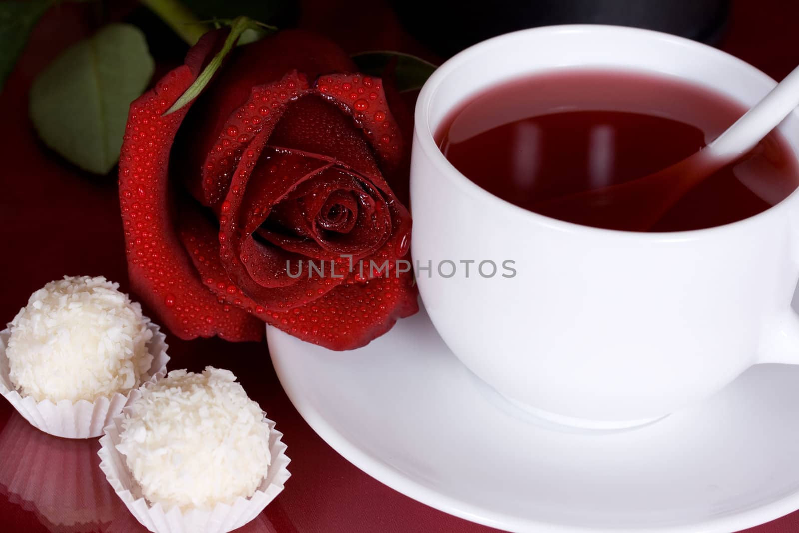 Romantic surprise in the form of a red rose, tea and chocolates