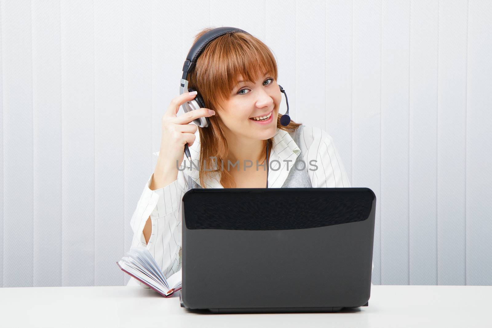 girl in headphones with a microphone and a laptop