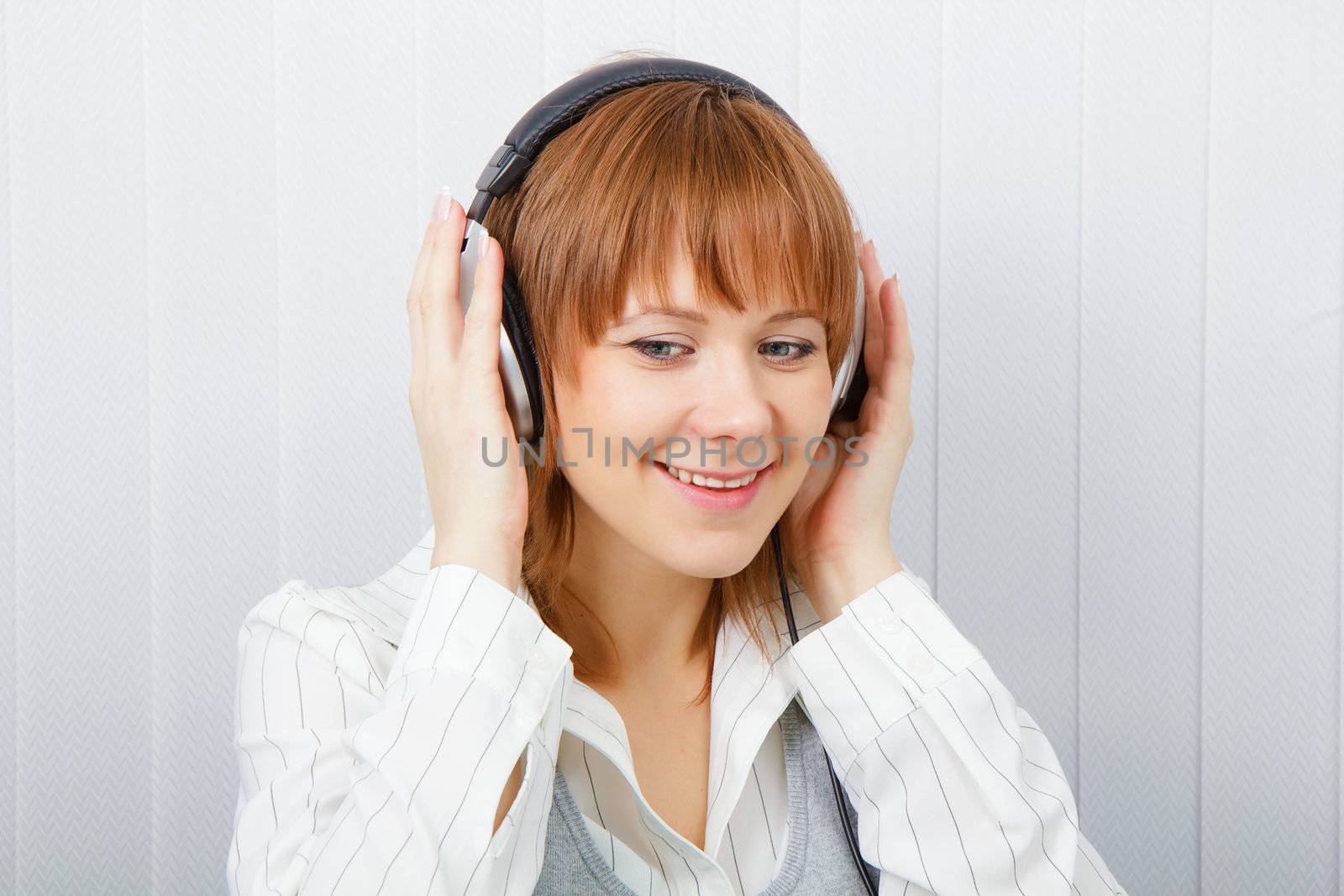 The girl in headphones listens to music with pleasure