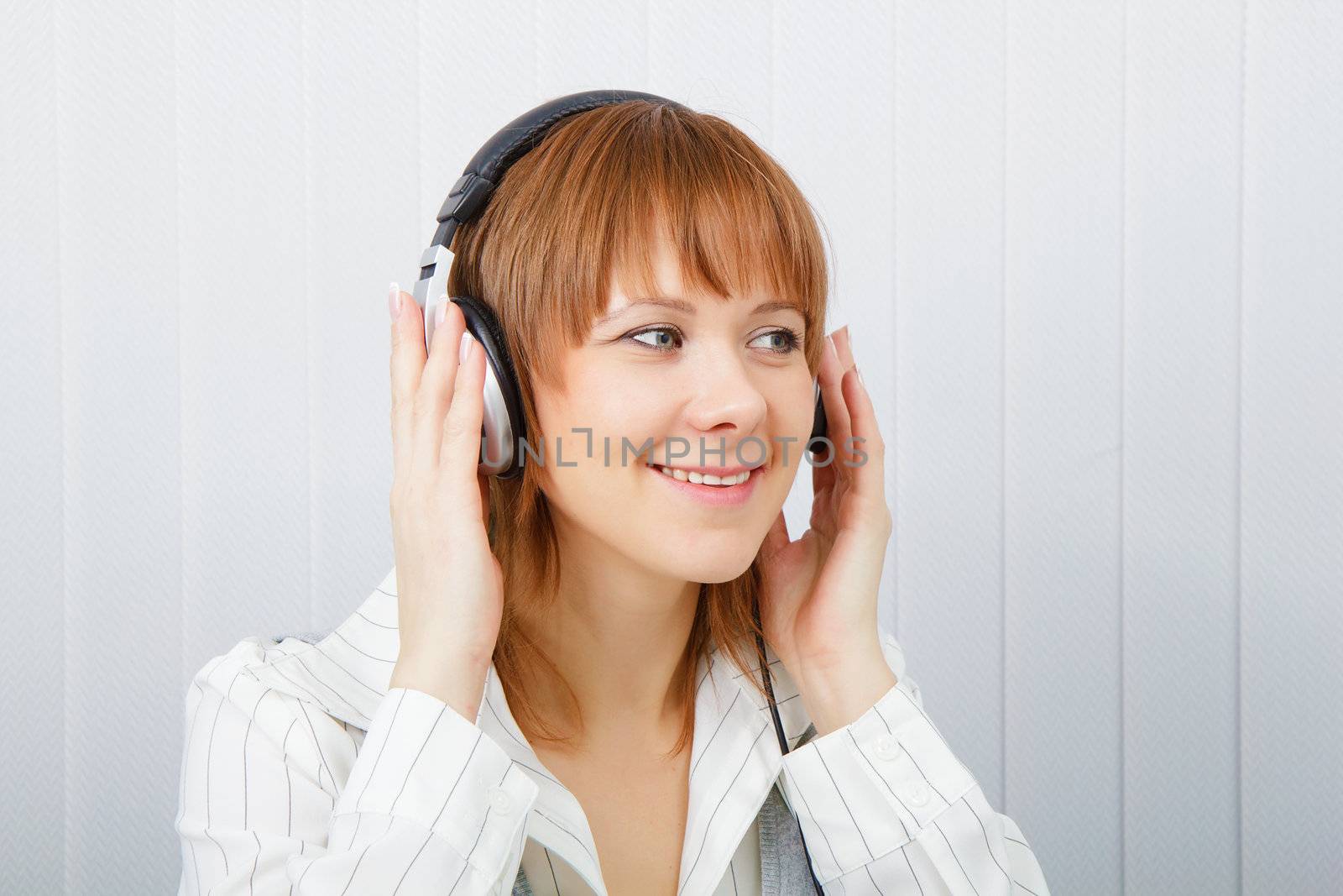 The girl in headphones listens to music with pleasure