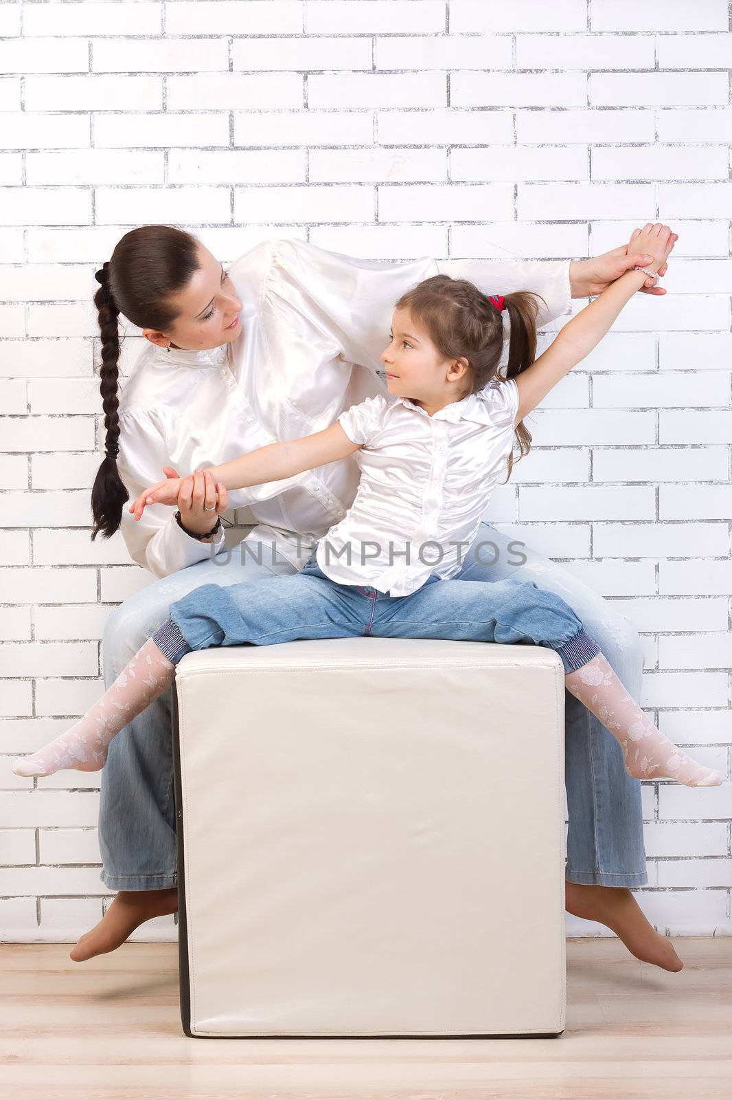 Mom and daughter in jeans and white shirts raised their hands