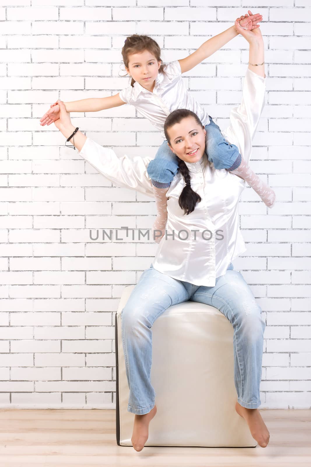 5 year old girl in jeans sitting on the neck of his mother
