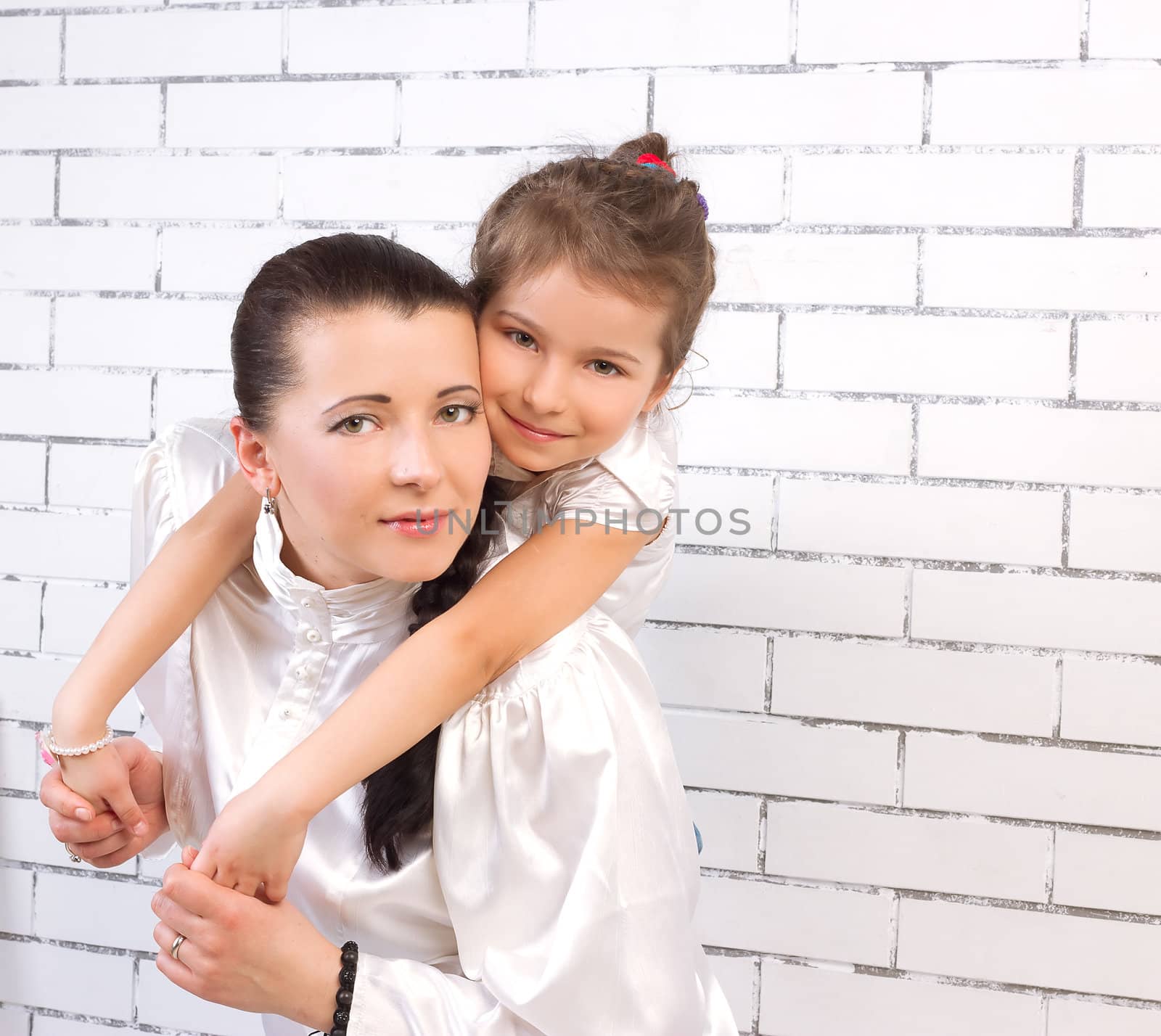 5 year old daughter in a white dress hugging her mom