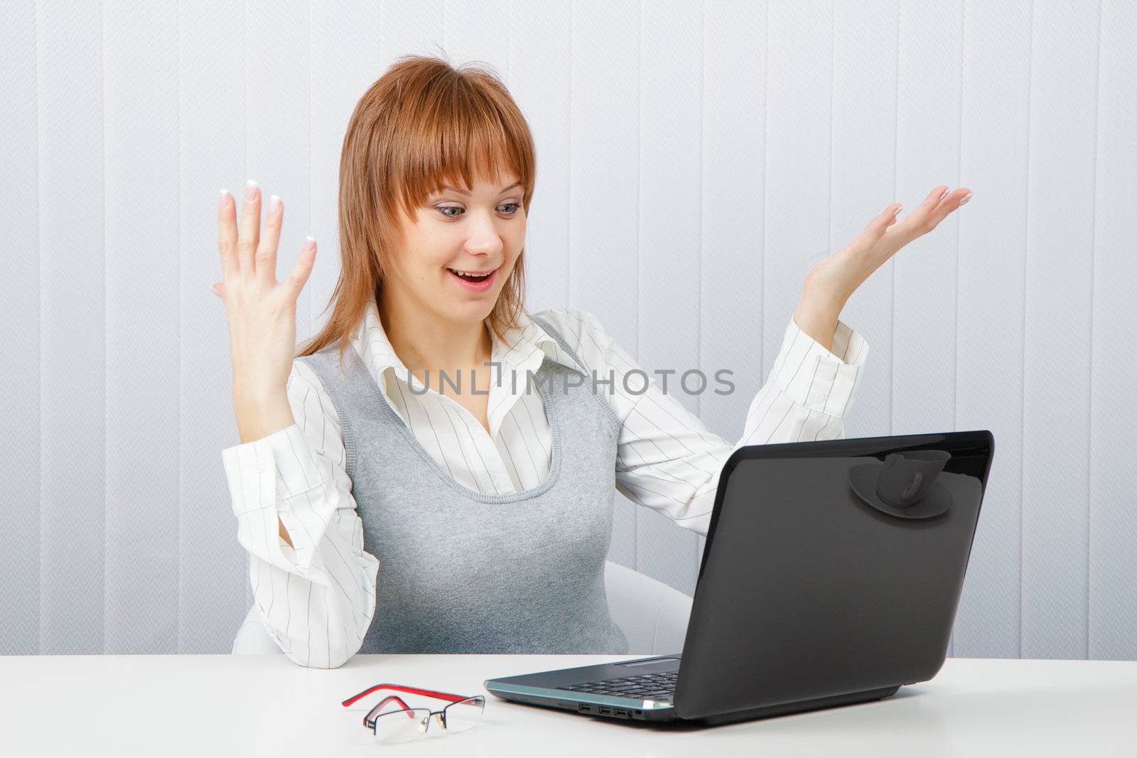 Delighted girl looks at a monitor. Office