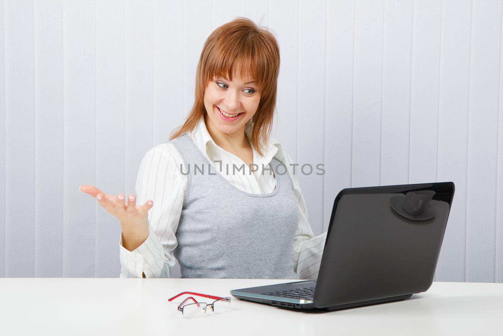 Delighted girl looks at a monitor. Office