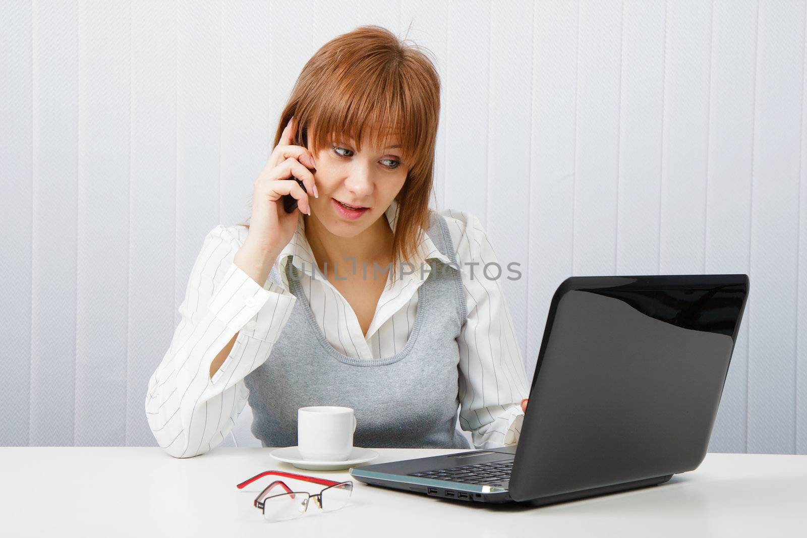 Attractive girl talking on the phone. Office